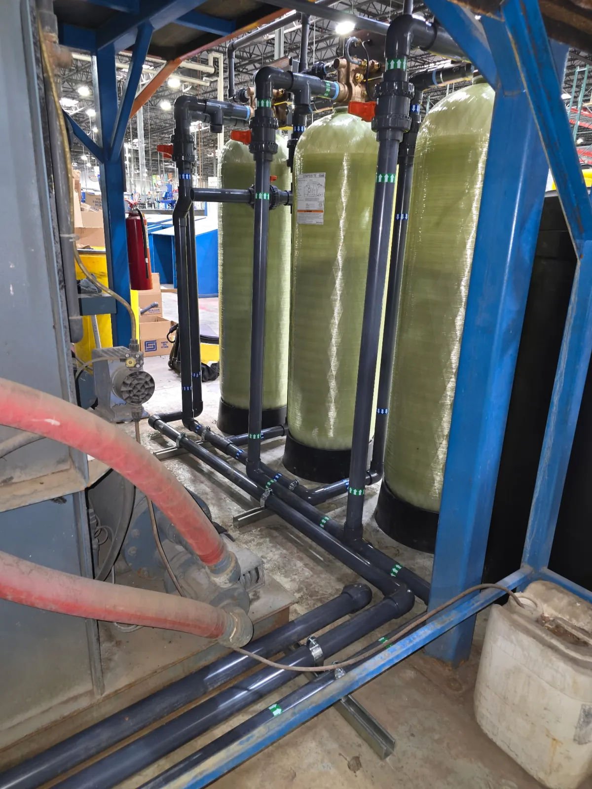 Multiple boiler makeup-water pretreatment vessels connected with labeled process piping in an industrial facility