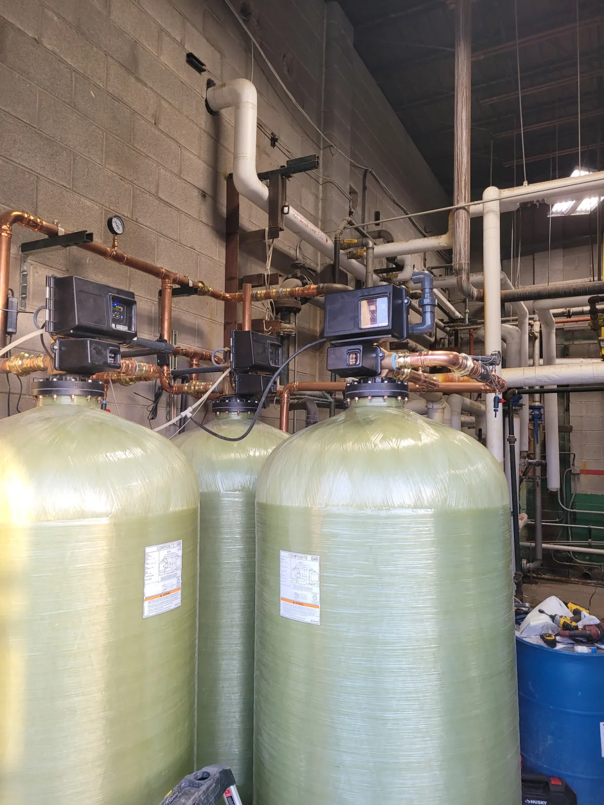 Commercial softener and carbon filtration vessels connected with copper headers and automatic control valves