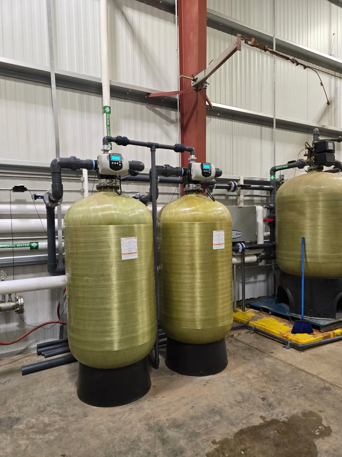 Two large commercial water treatment vessels with automatic control valves and a carbon tank