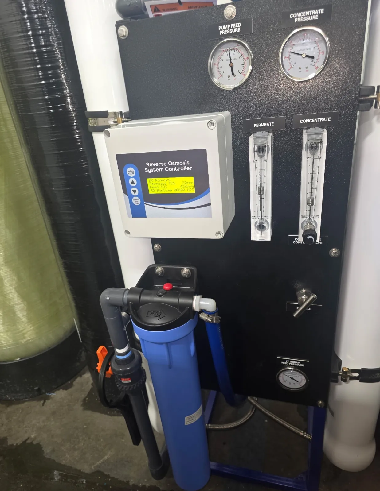 Close view of a reverse osmosis controller, pressure gauges, flow meters, and cartridge prefilter